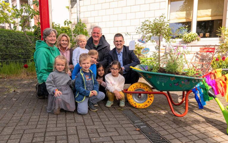 Kinder der Kita an der Krummenweger Straße und ihre Einrichtungsleiterin Claudia We-ber (2.v.l.) erläuterten Bürgermeister Patrick Anders (rechts) gern, wie sie die Schubkarre gestaltet und bepflanzt haben. Mit dabei waren Ursula Merlo und Heribert Müller vom städtischen Grünflächenamt.